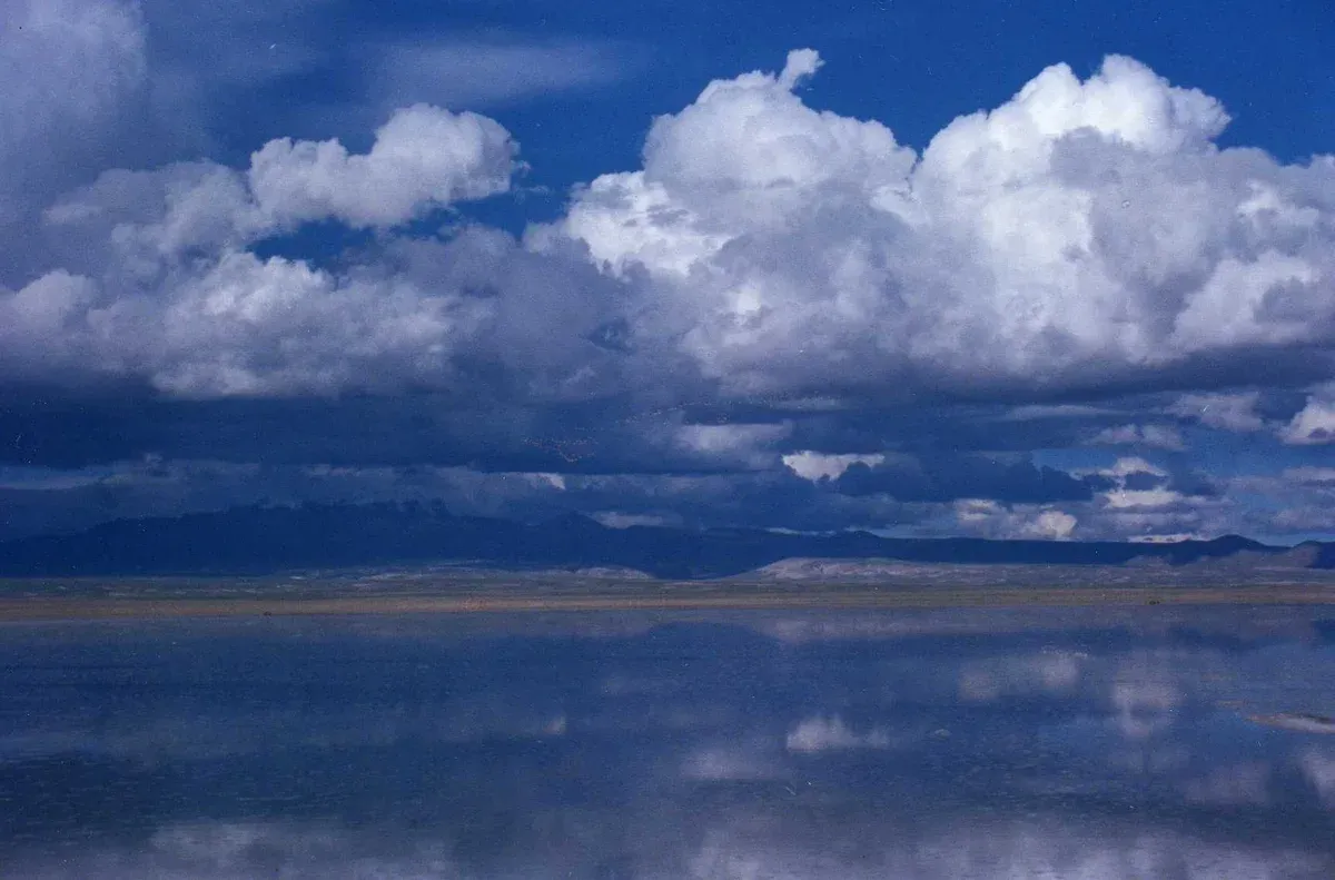 Clouds reflected in a thin sheet of water on the salar during an Uyuni salt flats tour